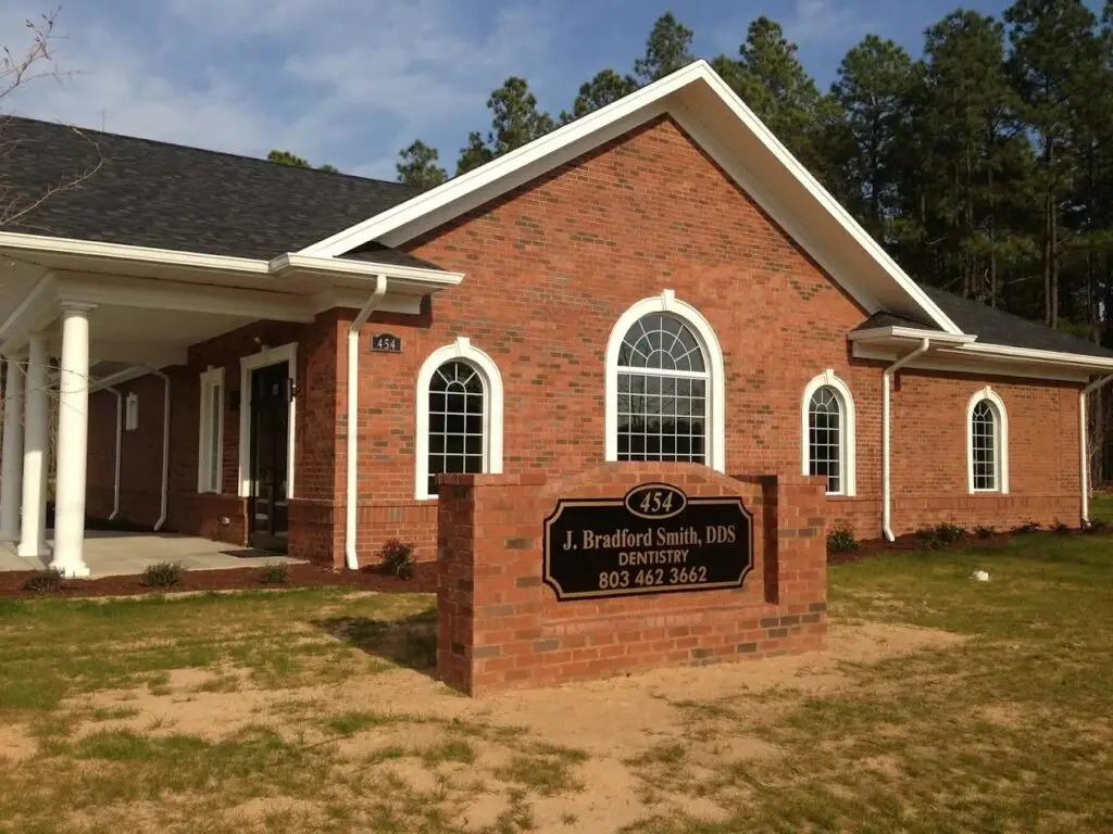 a brick building with a sign in front of it .